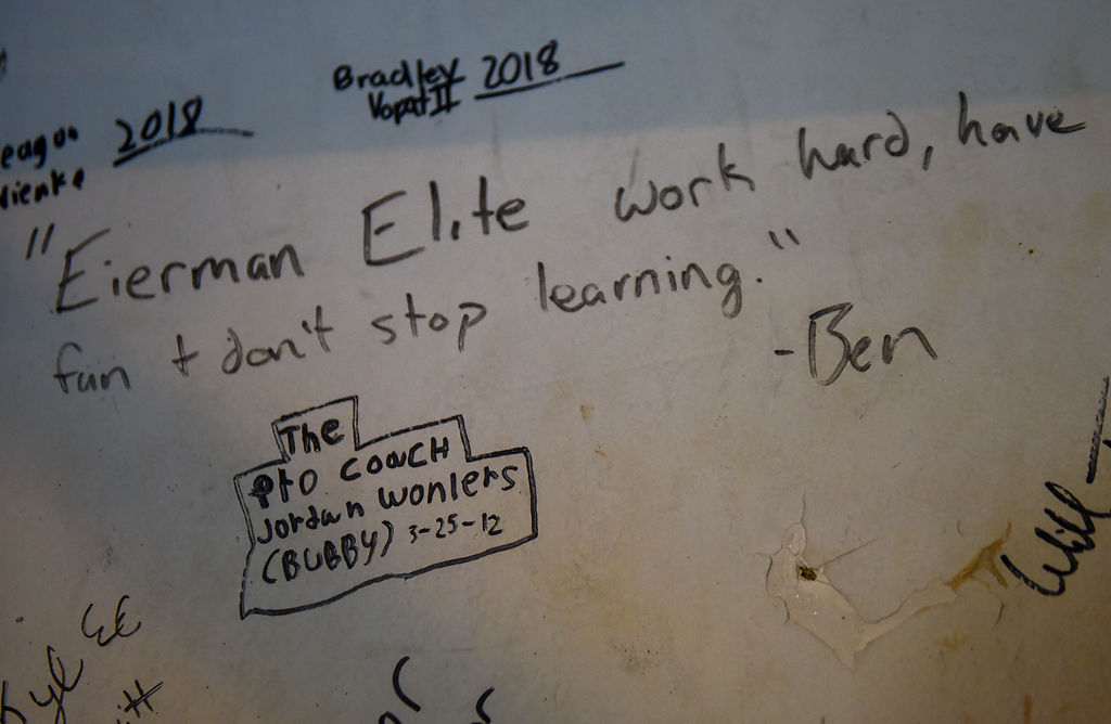 Notes from wrestlers mark the gym wall of Mark Eierman